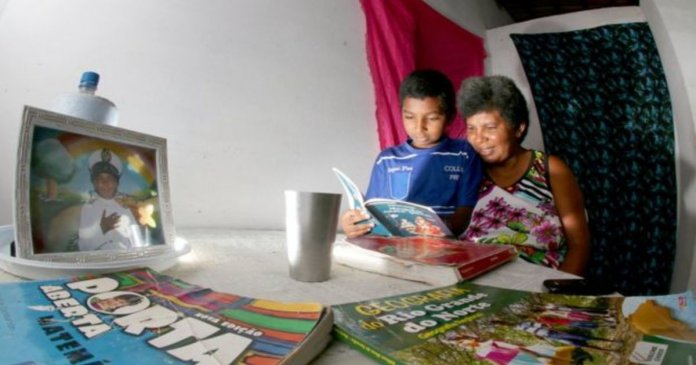 Menino de 11 anos ensina mãe catadora de lixo a ler e escrever
