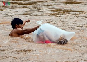 asomadetodosafetos.com - Crianças de uma vila no Vietnã atravessam rio de águas bravas em sacos plásticos para chegar à escola