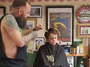 psicologiasdobrasil.com.br - Inclusão: Barbeiro deita no chão para cortar o cabelo de criança autista
