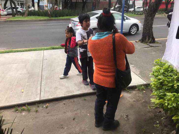 psicologiasdobrasil.com.br - Irmãozinhos assistem às aulas na rua, sentados no chão, usando internet pública