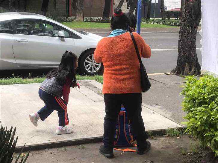 psicologiasdobrasil.com.br - Irmãozinhos assistem às aulas na rua, sentados no chão, usando internet pública