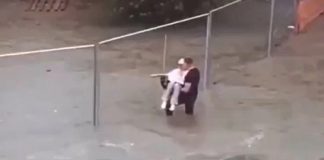 Homem resgata idosa agarrada a cerca enquanto as enchentes sobem ao redor dela