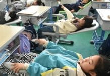 Em escolas da China, crianças usam mesas e cadeiras dobráveis para tirar uma soneca nos intervalos