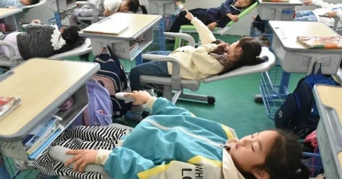 Em escolas da China, crianças usam mesas e cadeiras dobráveis para tirar uma soneca nos intervalos